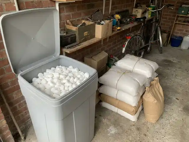 Bac à sel d'adoucisseur rempli de pastilles de sel dans un garage